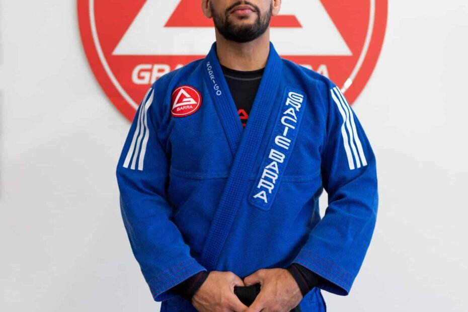 Professor Seidler Rodrigo posing in front of Gracie Barra logo